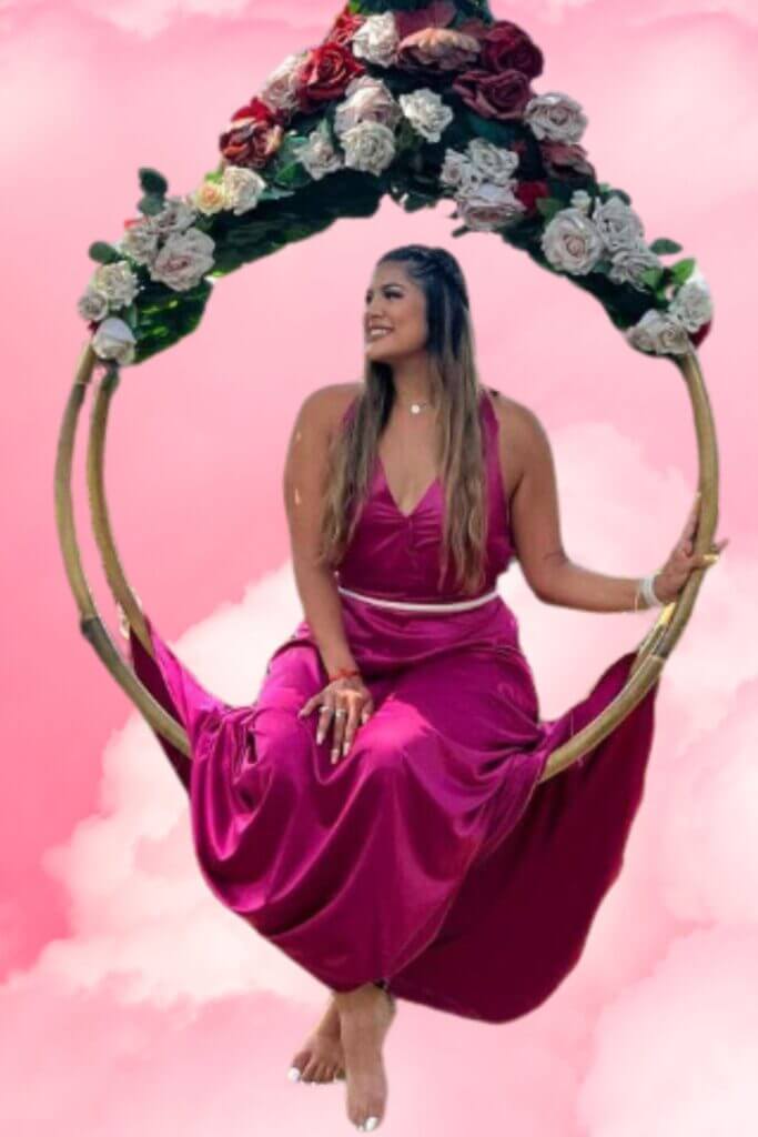 Women in swing with pink background